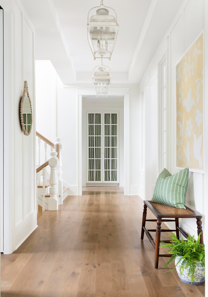 Идея дизайна: коридор в стиле неоклассика (современная классика) с белыми стенами, паркетным полом среднего тона и коричневым полом