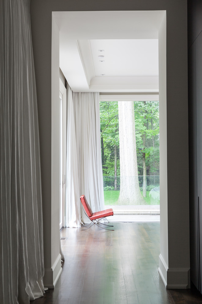 Réalisation d'un couloir minimaliste de taille moyenne avec un mur blanc et un sol en bois brun.