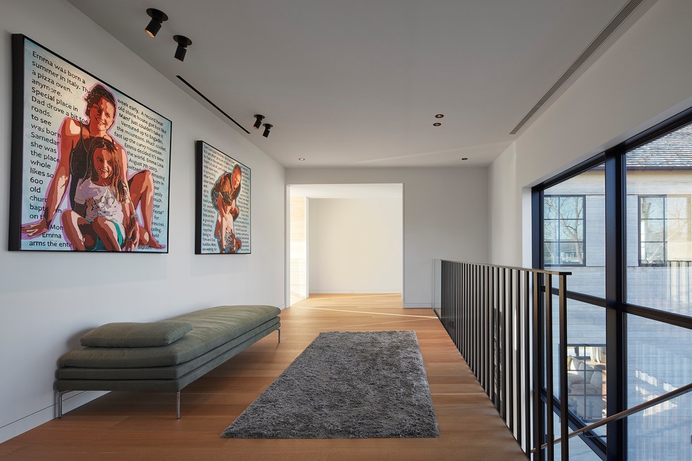 Immagine di un ingresso o corridoio minimal con pareti bianche, pavimento in legno massello medio e pavimento marrone