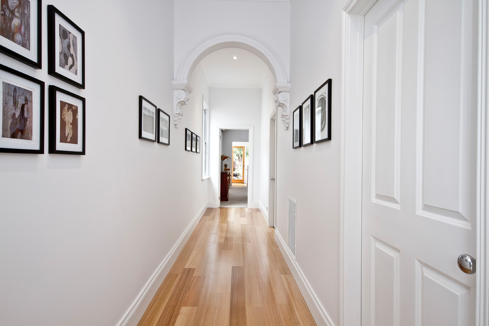 メルボルンにある小さなヴィクトリアン調のおしゃれな廊下 (白い壁、淡色無垢フローリング) の写真
