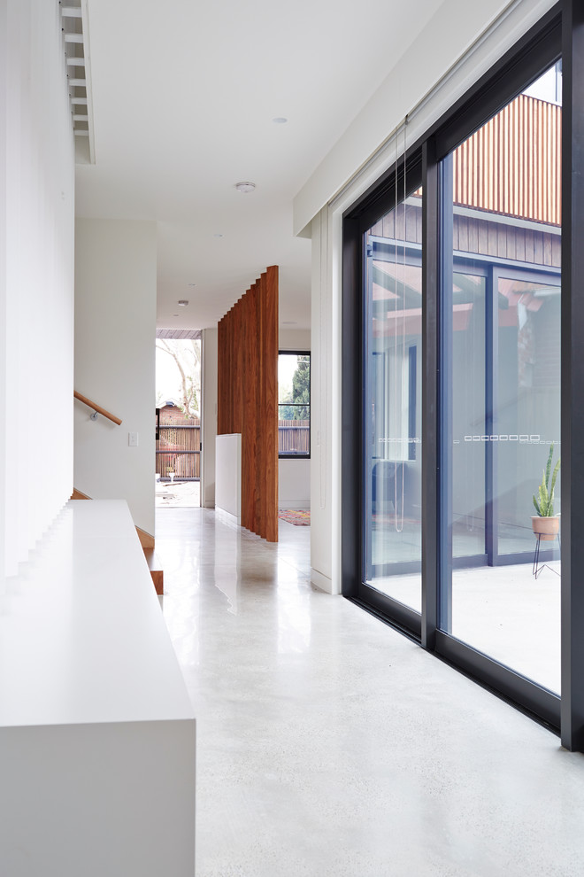 Свежая идея для дизайна: коридор в современном стиле с белыми стенами и бетонным полом - отличное фото интерьера