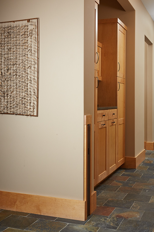 Exemple d'un grand couloir craftsman avec un mur beige et un sol en ardoise.
