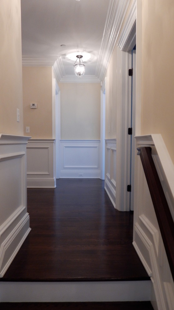 Example of a large transitional dark wood floor hallway design in New York with beige walls