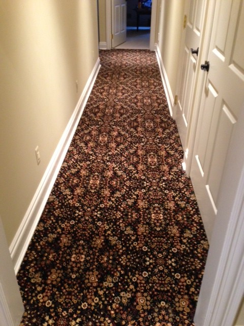 Inspiration for a large transitional carpeted hallway remodel in Detroit with beige walls