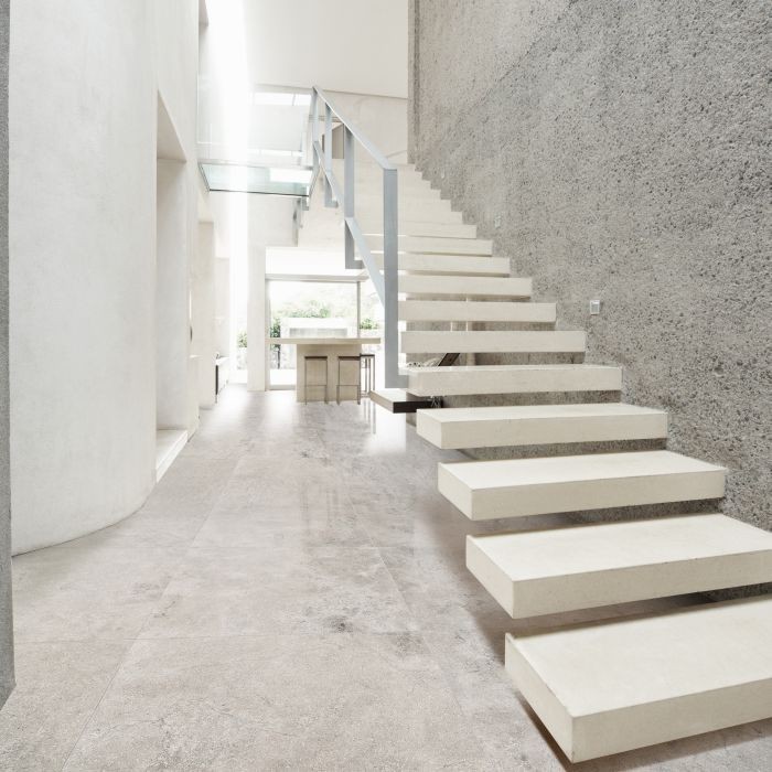 Idée de décoration pour un très grand couloir design avec un mur blanc et un sol en calcaire.