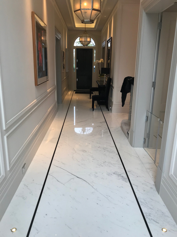 Cette image montre un grand couloir traditionnel avec un sol en marbre et un sol blanc.