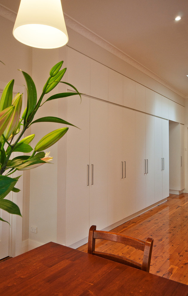 Mid-sized minimalist medium tone wood floor hallway photo in Melbourne with beige walls