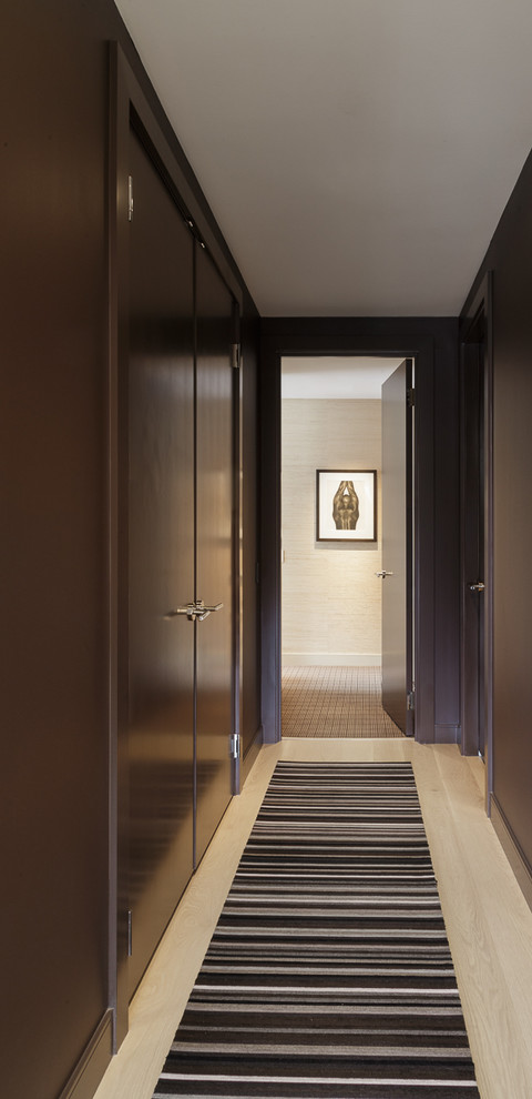 На фото: большой коридор в современном стиле с коричневыми стенами, полом из ламината и бежевым полом
