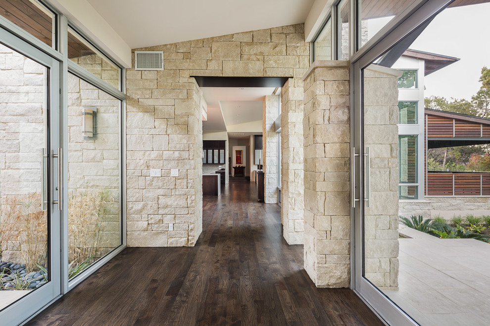 Inspiration for a contemporary dark wood floor and brown floor hallway remodel in Austin with beige walls
