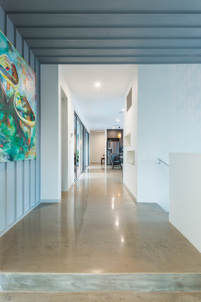 Idee per un ingresso o corridoio con pareti bianche, pavimento in cemento e pavimento grigio