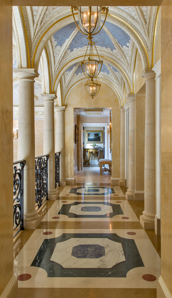 Klassisk inredning av en mellanstor hall, med marmorgolv, beige väggar och flerfärgat golv