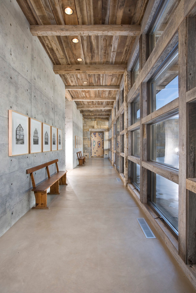 Réalisation d'un couloir chalet avec un mur gris et sol en béton ciré.