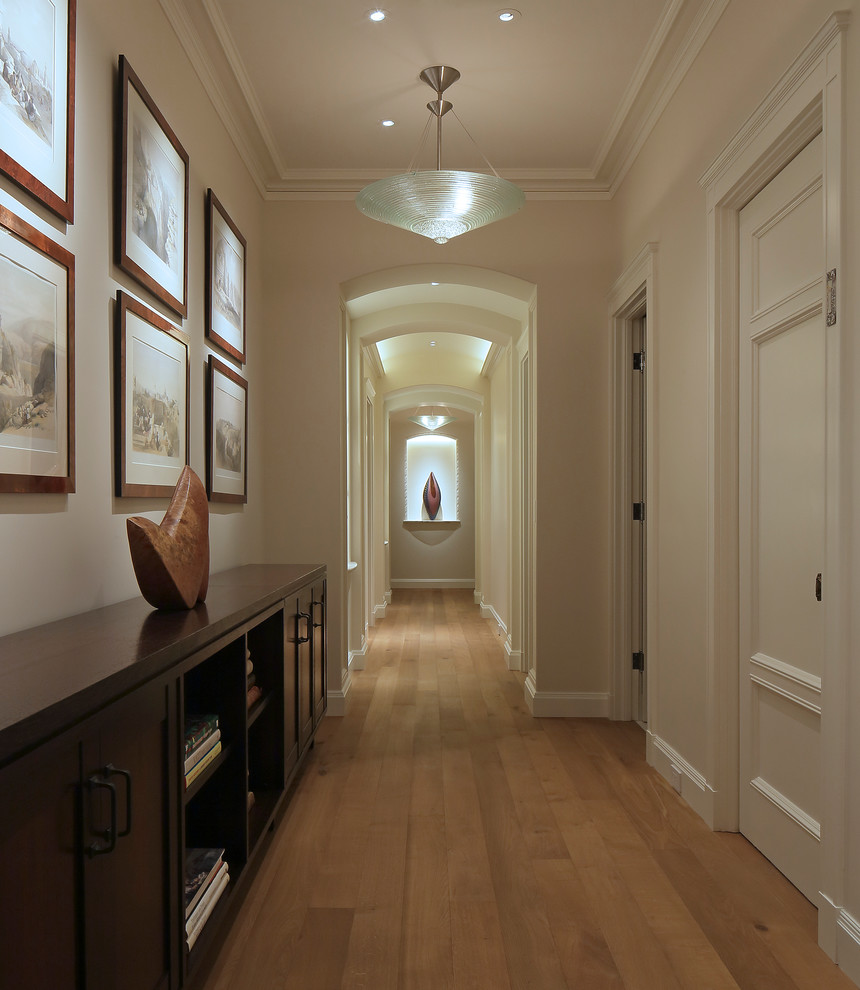 Ejemplo de recibidores y pasillos clásicos con paredes beige y suelo de madera clara