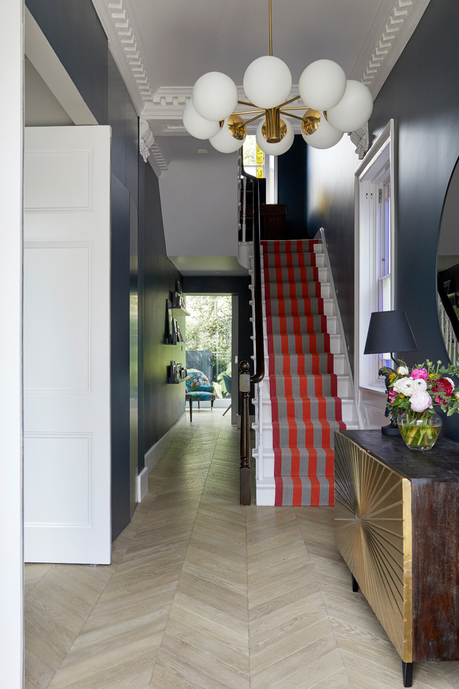 Diseño de recibidores y pasillos modernos con paredes azules, suelo de madera oscura, suelo beige y iluminación