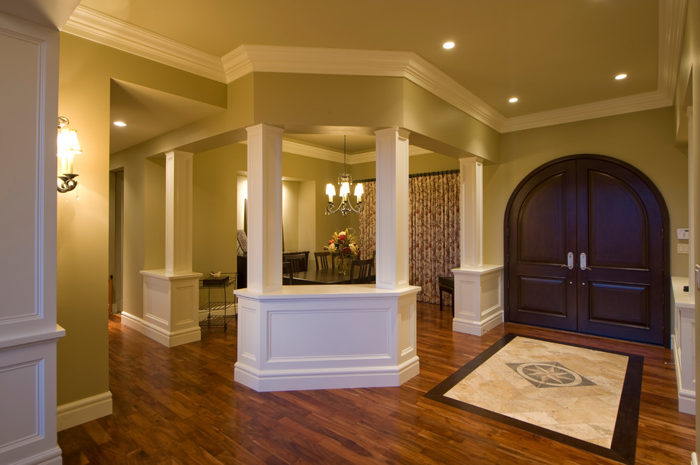Cette image montre un grand couloir craftsman avec un mur beige et un sol en bois brun.
