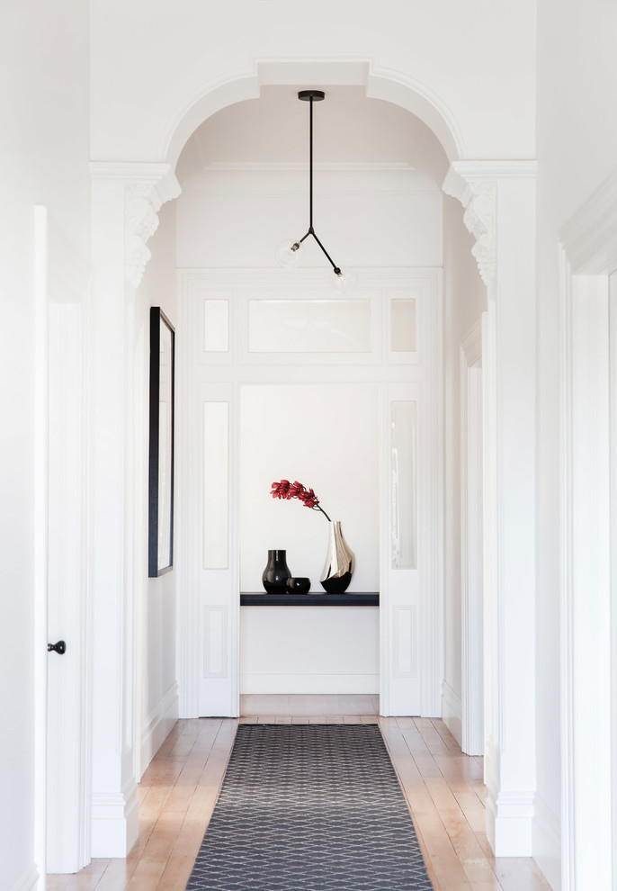 Idées déco pour un couloir classique avec un mur blanc et parquet clair.