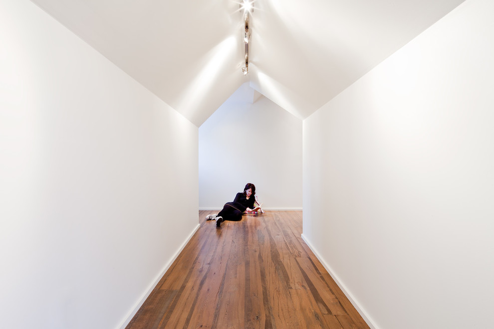 Ejemplo de recibidores y pasillos rústicos con paredes blancas y suelo de madera en tonos medios