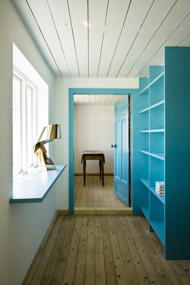 Example of a danish medium tone wood floor hallway design in Copenhagen with blue walls