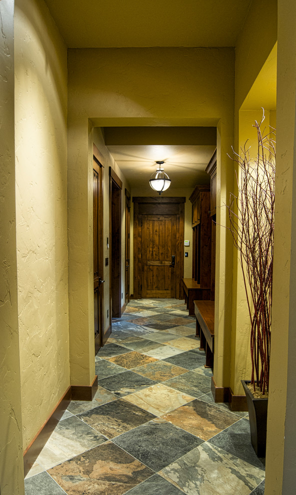 Réalisation d'un couloir chalet avec un mur beige et un sol en ardoise.