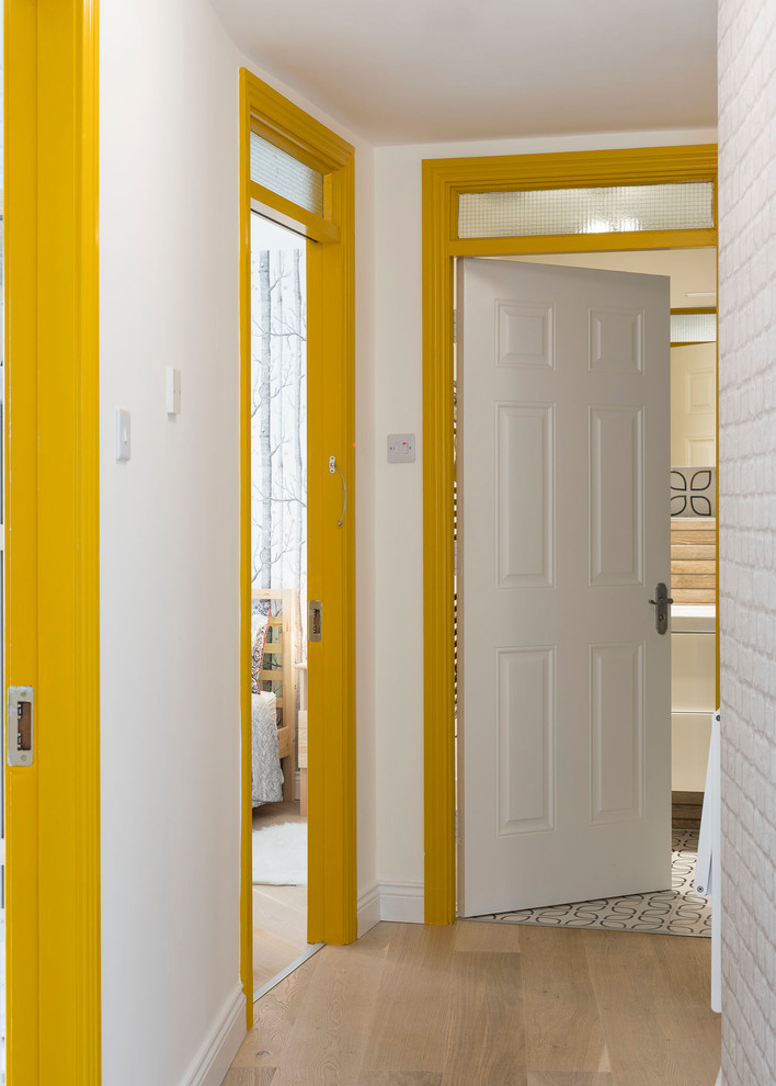 Idées déco pour un petit couloir scandinave avec un mur blanc, un sol en bois brun et un sol beige.