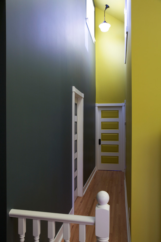 На фото: коридор среднего размера в стиле неоклассика (современная классика) с разноцветными стенами, паркетным полом среднего тона и коричневым полом
