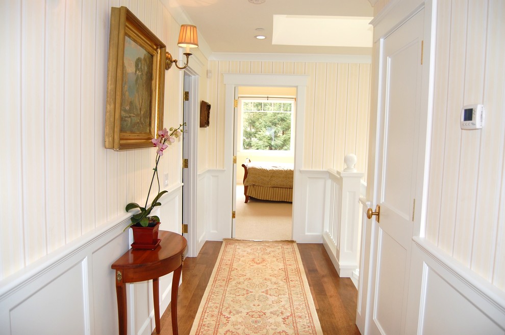Idée de décoration pour un couloir tradition de taille moyenne avec un mur blanc, parquet foncé et un sol marron.