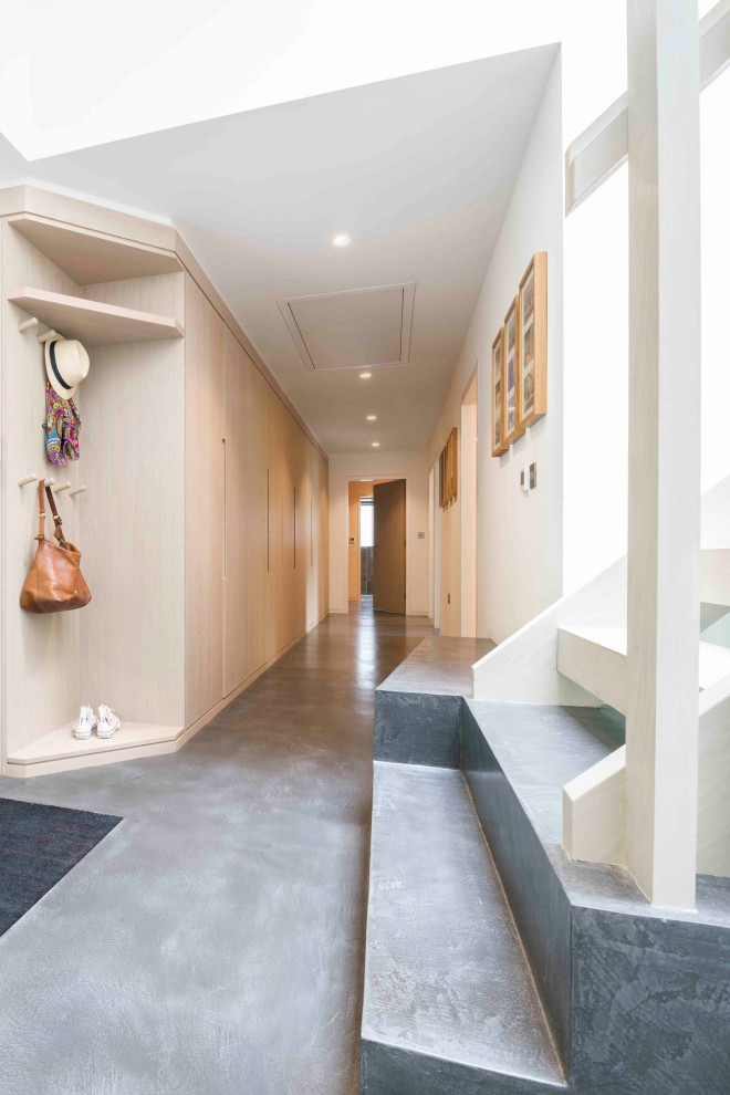 Свежая идея для дизайна: коридор среднего размера в современном стиле с белыми стенами, бетонным полом и серым полом - отличное фото интерьера