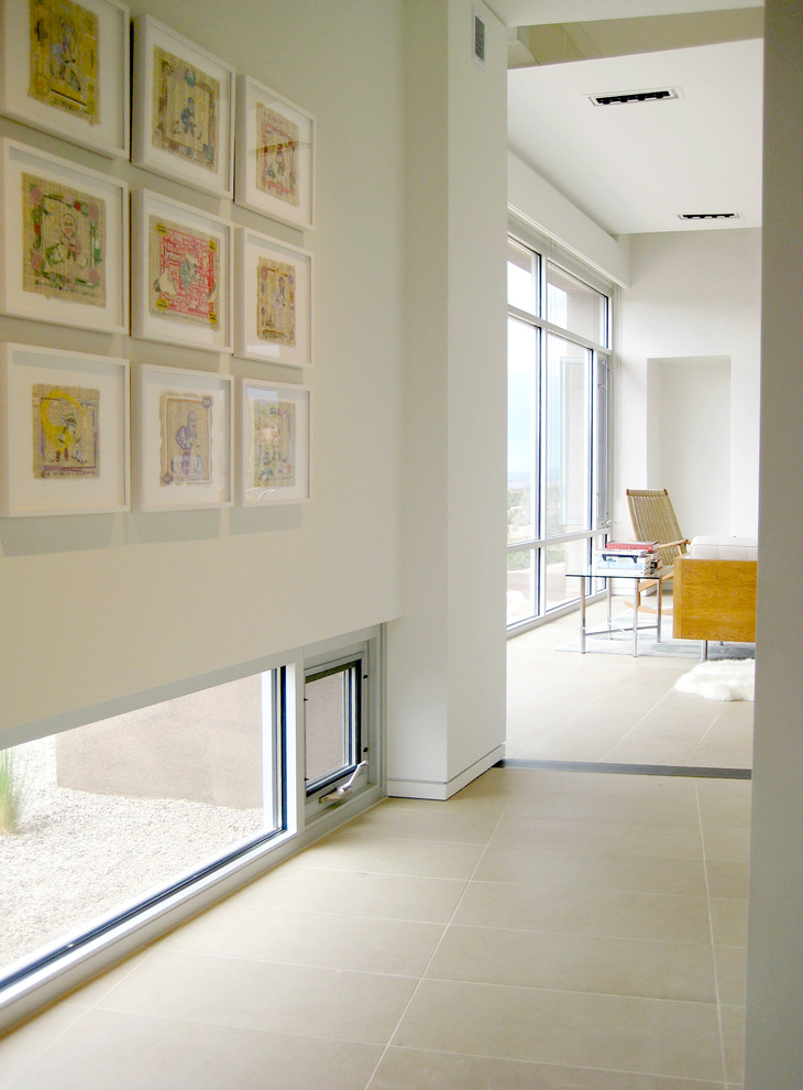 Ejemplo de recibidores y pasillos actuales de tamaño medio con paredes blancas y suelo de baldosas de porcelana