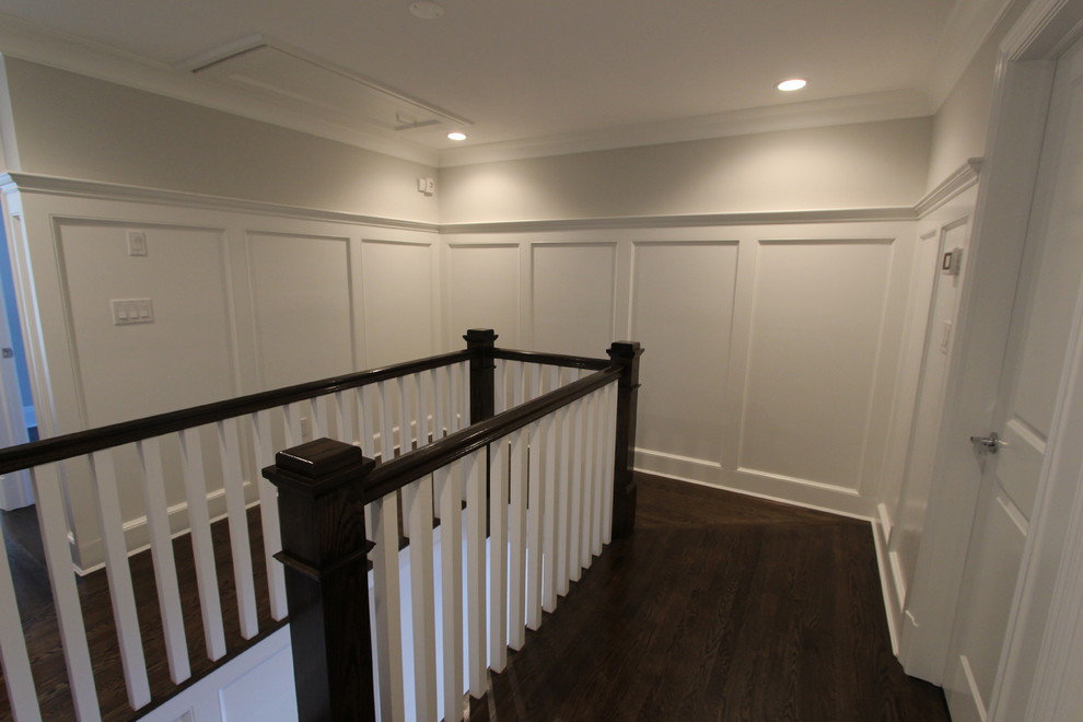 На фото: коридор в стиле неоклассика (современная классика) с серыми стенами и темным паркетным полом с