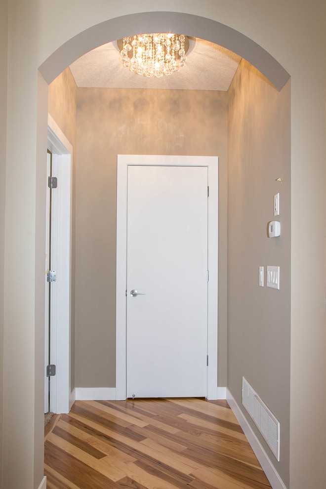 Idee per un ingresso o corridoio chic con pareti beige e pavimento in legno massello medio