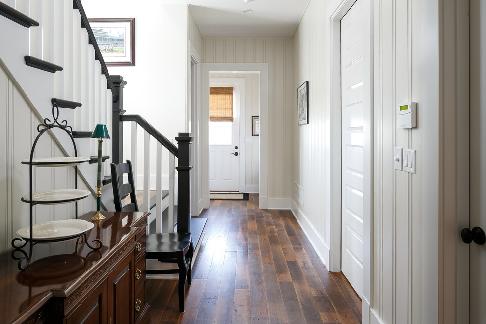 Idées déco pour un couloir classique avec un mur blanc et un sol en bois brun.