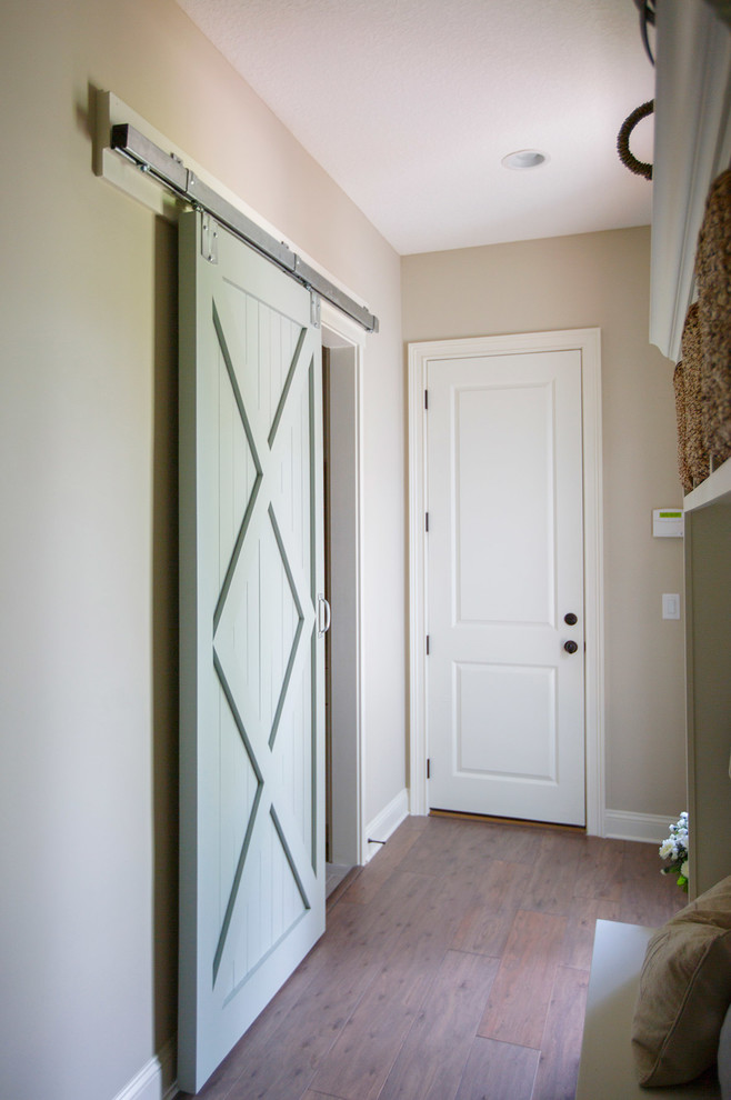 Idées déco pour un couloir craftsman de taille moyenne avec un mur beige, parquet foncé et un sol marron.