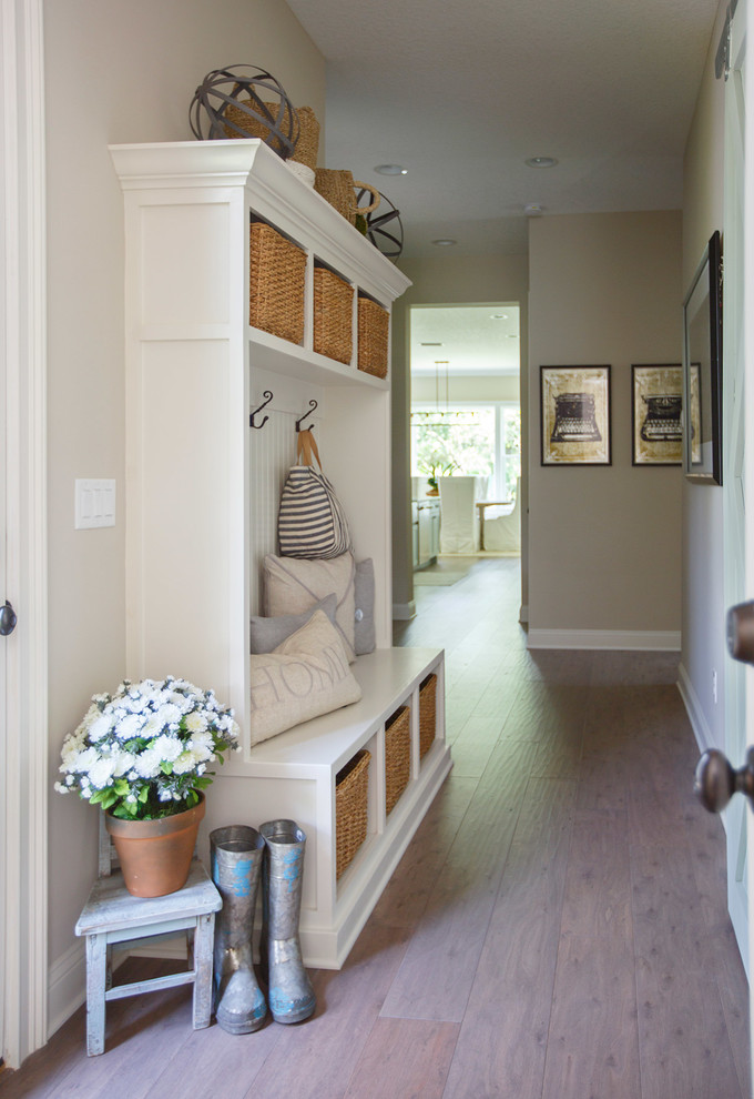 Aménagement d'un couloir classique de taille moyenne avec un mur beige, un sol en bois brun et un sol marron.