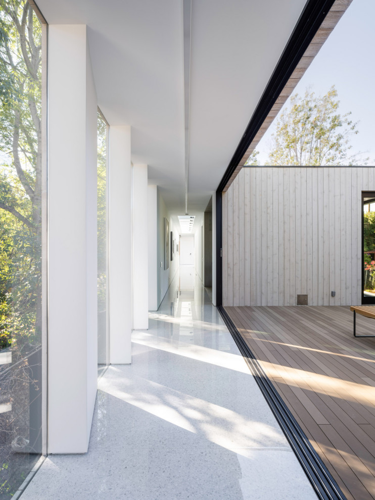 Diseño de recibidores y pasillos minimalistas con paredes blancas, suelo de terrazo y suelo blanco