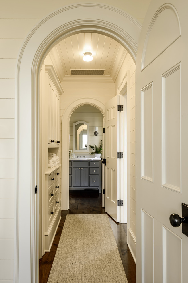 Идея дизайна: коридор в классическом стиле с белыми стенами, темным паркетным полом и коричневым полом