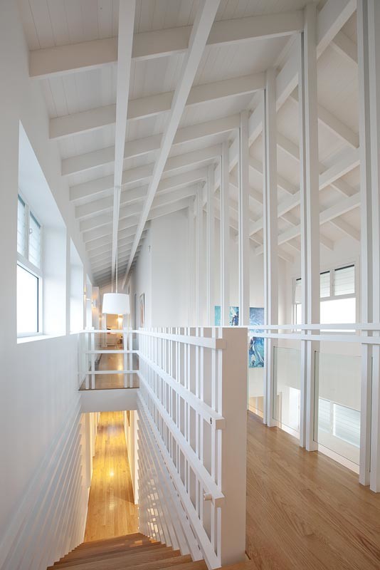 Cette image montre un couloir design avec un mur blanc et parquet clair.