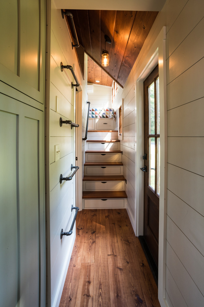 Idées déco pour un couloir craftsman avec un sol en bois brun.