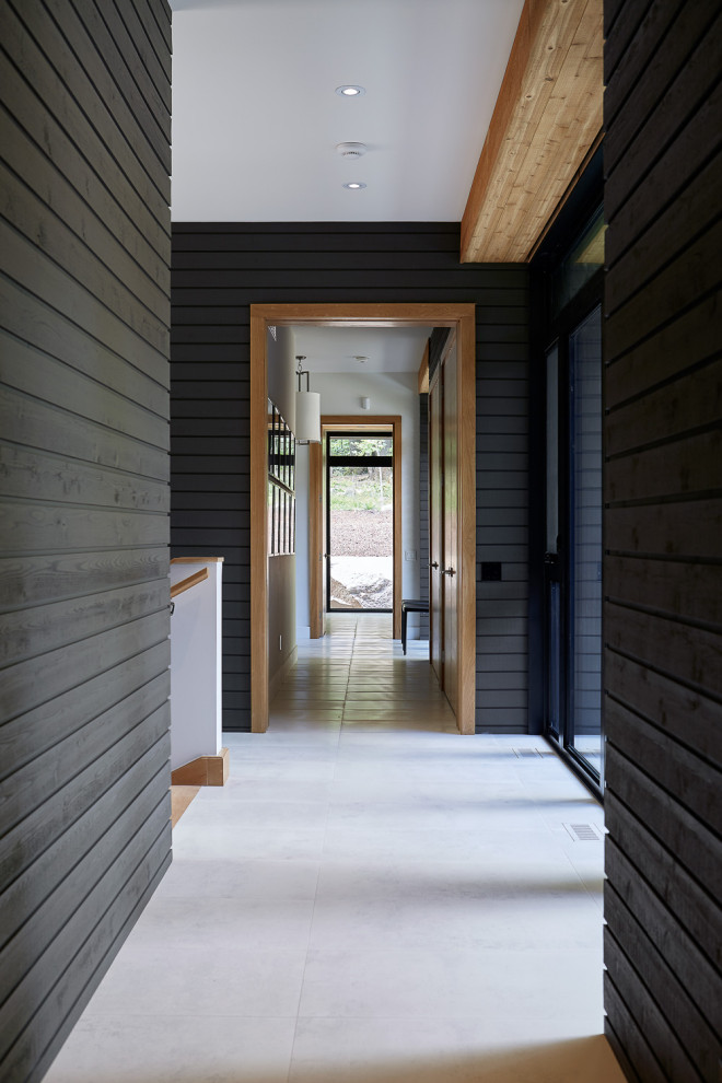 Diseño de recibidores y pasillos minimalistas de tamaño medio con paredes negras, suelo de baldosas de porcelana y suelo blanco