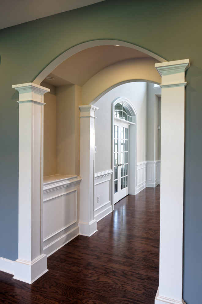Esempio di un piccolo ingresso o corridoio classico con pavimento marrone, pareti blu, parquet scuro e boiserie