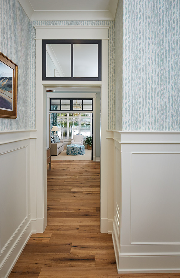 Mid-sized transitional light wood floor and brown floor hallway photo in Grand Rapids with blue walls