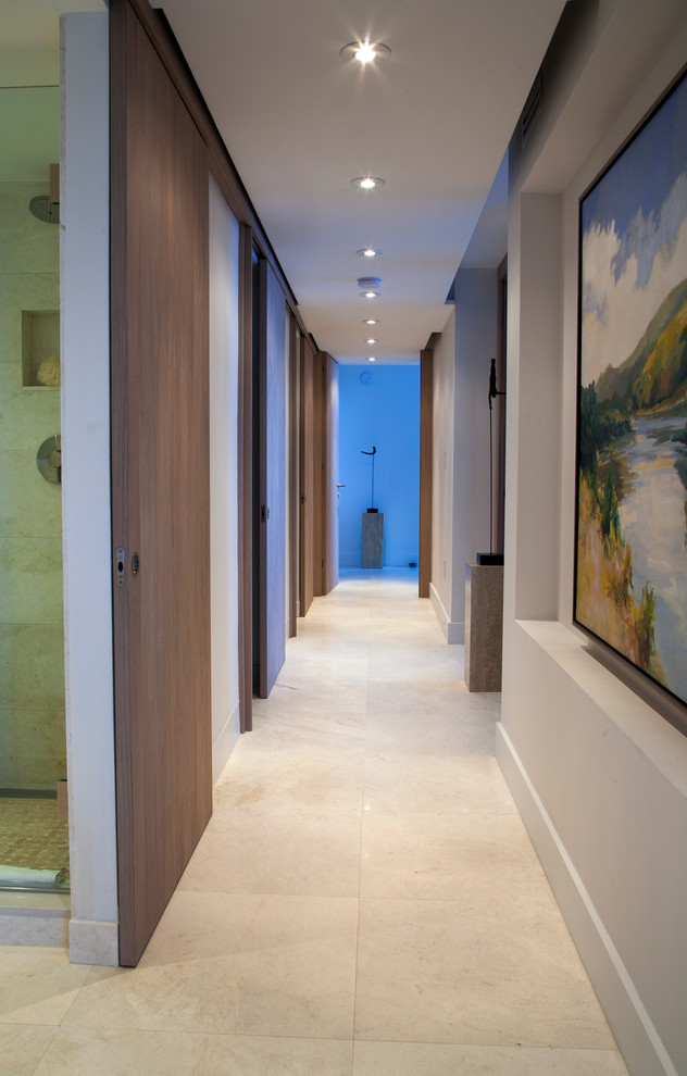 Пример оригинального дизайна: большой коридор в стиле модернизм с белыми стенами, бежевым полом и полом из известняка