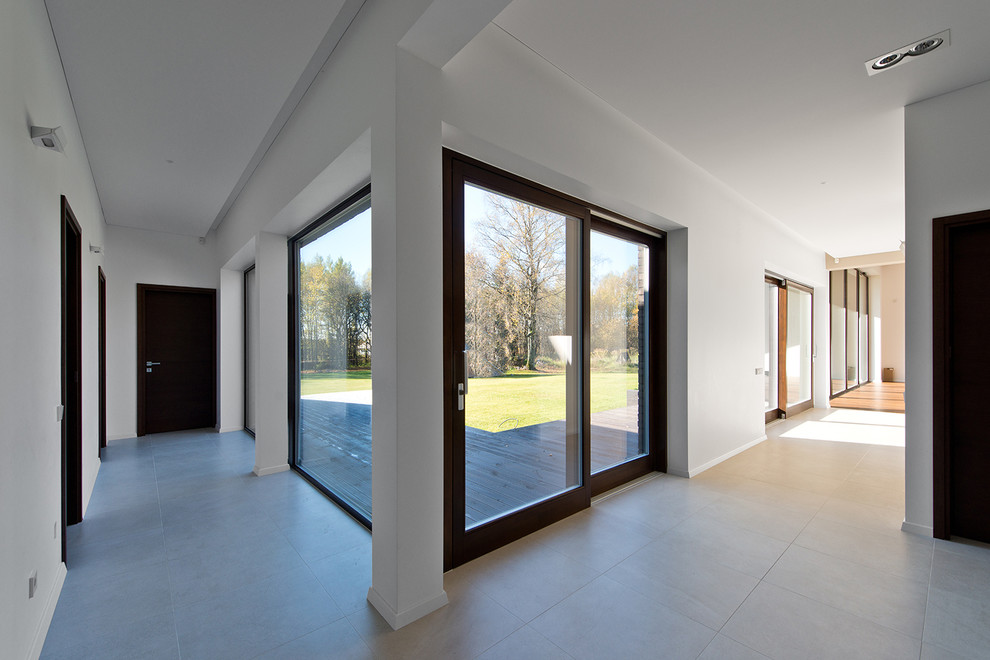 Ispirazione per un ingresso o corridoio design di medie dimensioni con pareti bianche e pavimento con piastrelle in ceramica