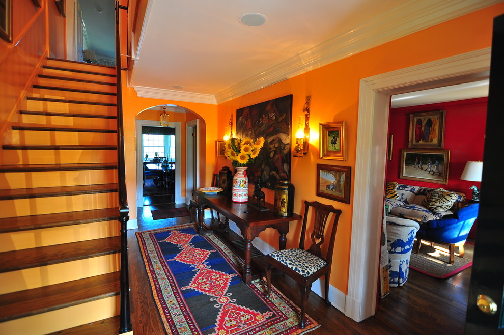 На фото: коридор среднего размера в классическом стиле с оранжевыми стенами и темным паркетным полом с