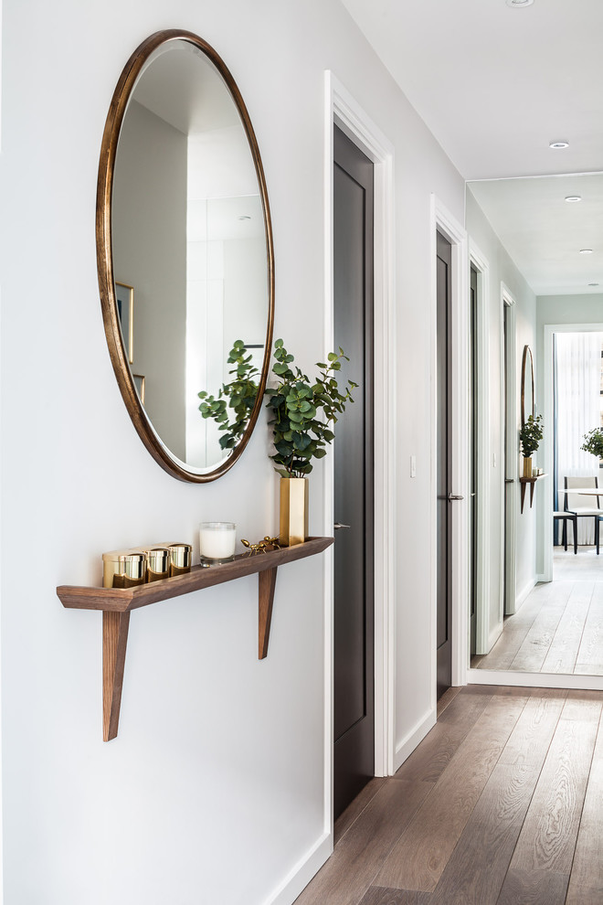 Inspiration pour un petit couloir design avec un mur blanc, un sol en bois brun et un sol marron.