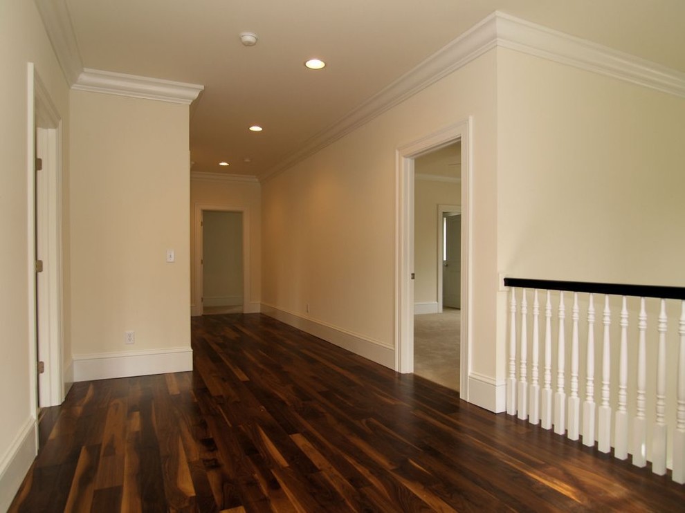 Exemple d'un couloir de taille moyenne avec un mur blanc et un sol en bois brun.