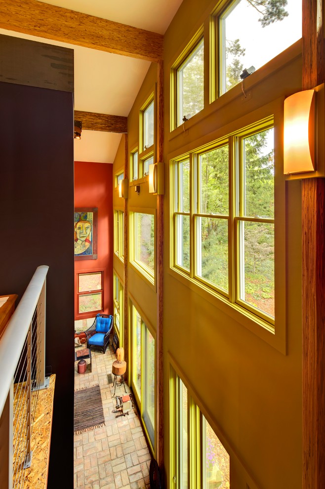 Esempio di un ingresso o corridoio design di medie dimensioni con pareti gialle, pavimento in mattoni e pavimento beige