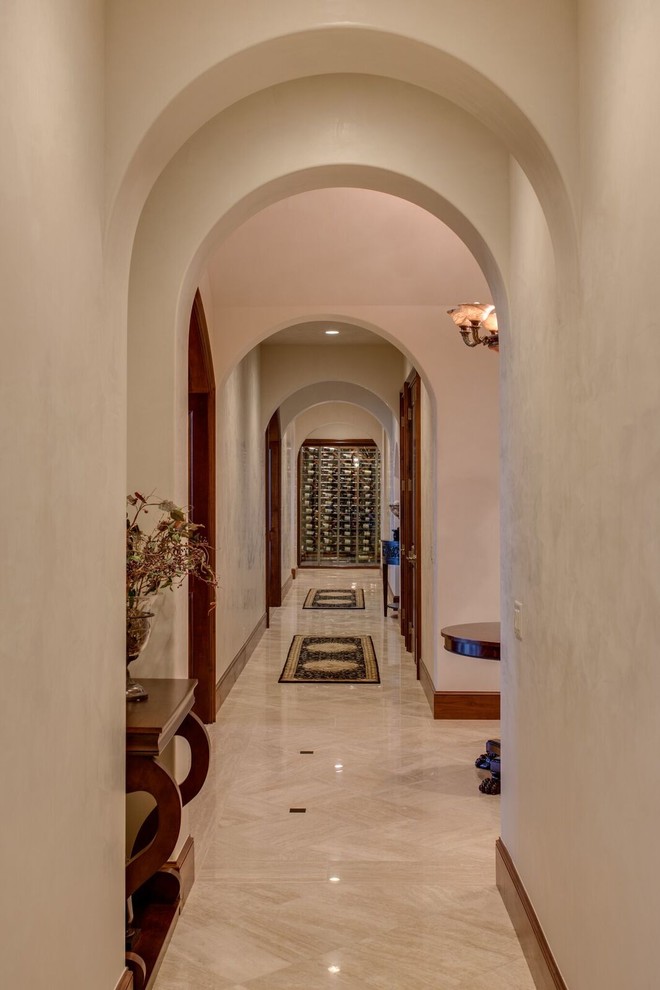 Exemple d'un couloir chic de taille moyenne avec un mur beige, un sol en carrelage de porcelaine et un sol beige.