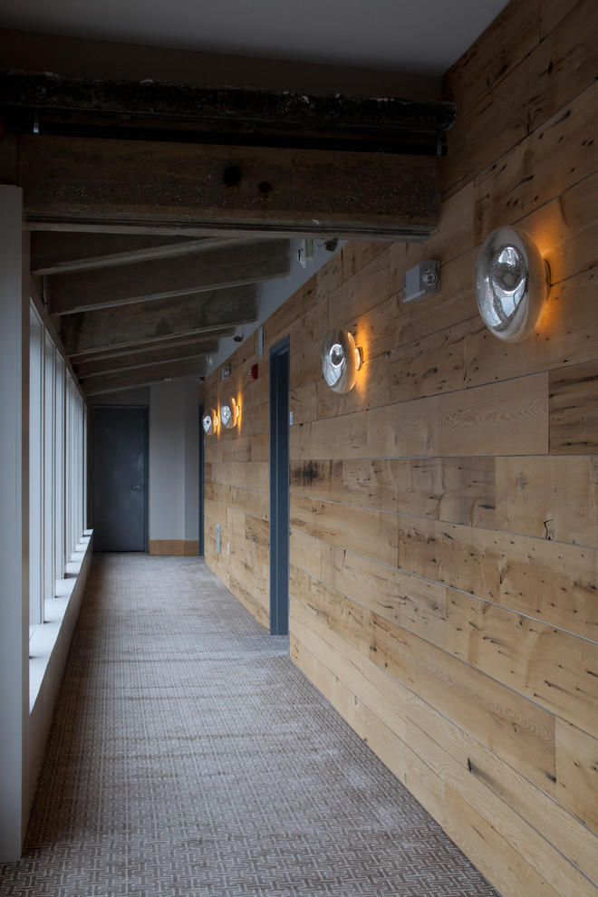 Inspiration pour un grand couloir chalet en bois avec un mur marron, moquette et un sol gris.