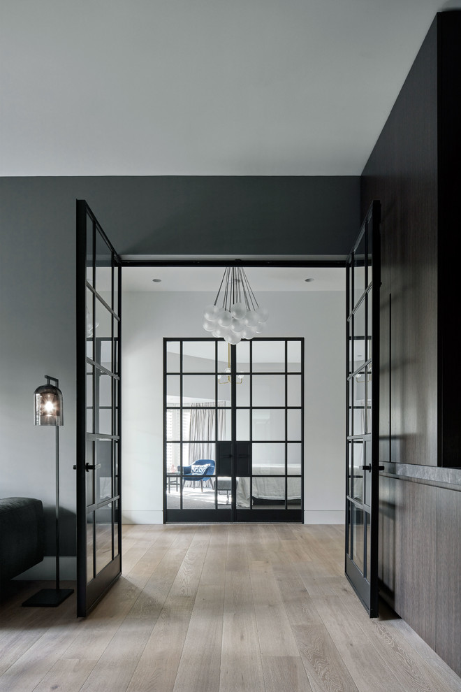 Cette image montre un grand couloir design avec un mur gris, parquet clair et un sol marron.