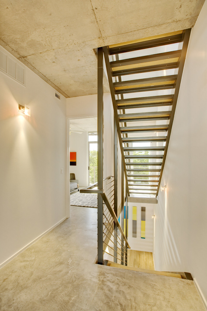 Inspiration for a contemporary concrete floor and beige floor hallway remodel in Austin with white walls